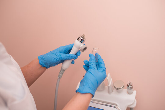 The cosmetologist includes a device for carrying out the procedure, attachments to the HydraFacial device for facial skin care in a spa clinic to combat acne or aging.