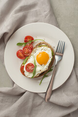 Toasts with egg and avocado on a gray background in a plate. healthy breakfast