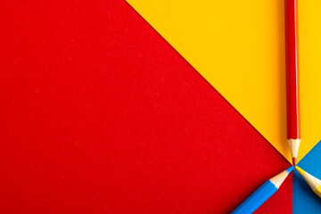 Close up of red, yellow and blue pencils with copy space on red, yellow and blue background