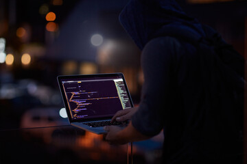Hacker, ransomware and programming with person and laptop for code, cyber security and phishing. Coding, technology and crime with programmer typing for fraud, network system and data scam at night