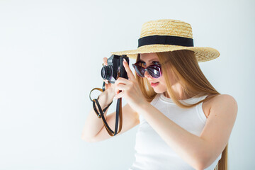 Young girl photographer in hat with camera in hands taking picture