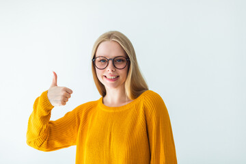Portrait of young beauty caucasian blondie woman in eye glasses looking at camera smiling and thumbs up