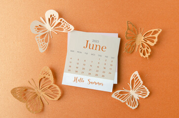 The Hello Summer June 2023 calendar with butterfly paper on orange color background.