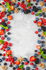 Various fresh summer berries on a gray concrete background. Healthy food concept. Top view. Food background.
