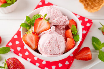 Strawberry ice cream with fresh berries in a bowl on a white wooden background. Selective focus