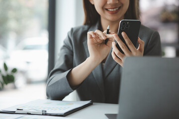 Woman holding a mobile phone and surfing the internet, executing apps on smartphone, answering...