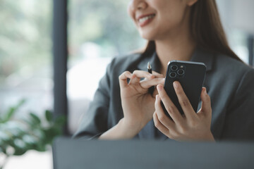 Woman holding a mobile phone and surfing the internet, executing apps on smartphone, answering...