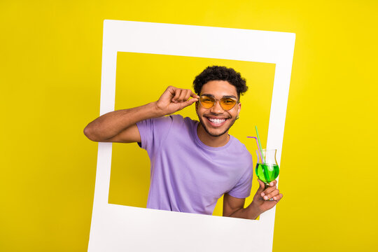 Photo of funky cheerful handsome man arm touch sunglass hold cocktail glass album set card isolated on yellow color background