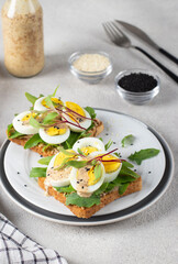 Homemade sandwiches with egg, arugula and cheese sprinkled with sesame seeds