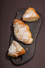 Good morning concept. Fresh croissants with cream filling and almond flakes. Sweet dessert