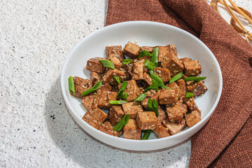 Fried teriyaki Tofu with scallions and sesame seeds. Healthy vegan meatless meal rich in protein
