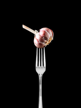 Cabe&ccedil;a de alho espetado num garfo na vertical