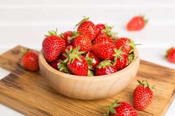 Fresh strawberries in bowl on wooden table