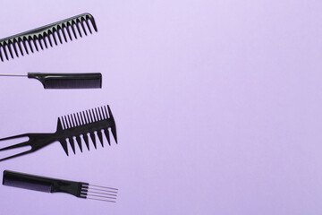 Professional combs and hairdresser tools on color background, top view