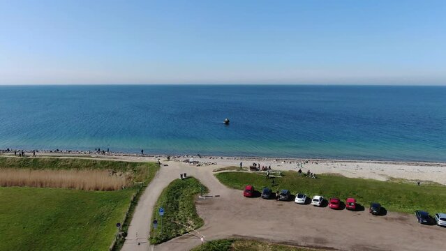 Westermarkelsdorf auf Fehmarn mit Deich, grünen Wiesen und Strand am blauen Ostseemeer: Malerisches Küstenjuwel, Luftaufnahme