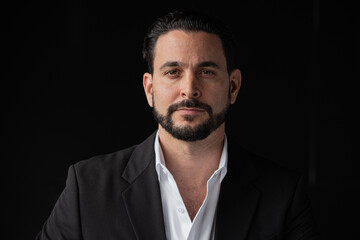 Portrait of handsome businessman against black background