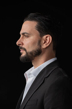 Profile view portrait of handsome businessman against black background