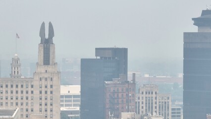 Fototapeta na wymiar Poor air quality in Rochester NY caused by Canadian wildfire smoke over the city skyline dense around downtown office buildings due to climate change conditions in Canada