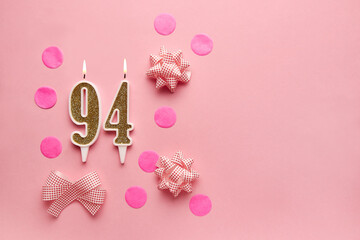 Number 94 on pastel pink background with festive decor. Happy birthday candles. The concept of celebrating a birthday, anniversary, important date, holiday. Copy space. banner