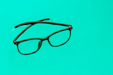 glasses with black frames isolated on green background