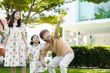 asian family Parents and daughters doing a happy walk in the village garden. During the holidays weekends to relax. friendship and living together. member health care. Concept health insurance