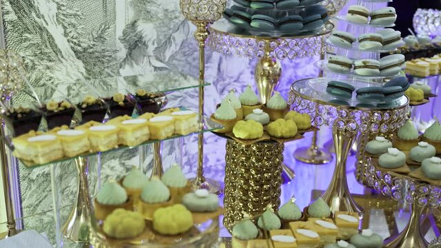 Candy bar. Sweets on stands. Delicious desserts at the banquet. Mousse desserts, almond flour macaroons, sponge cakes, shortbread tarts. Confectionery at the celebration. Sweets with sugar