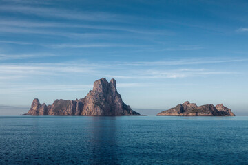 The island of es vedra in sunny day, beautiful reflection of blue sky, Ibiza, Spain - 611024775