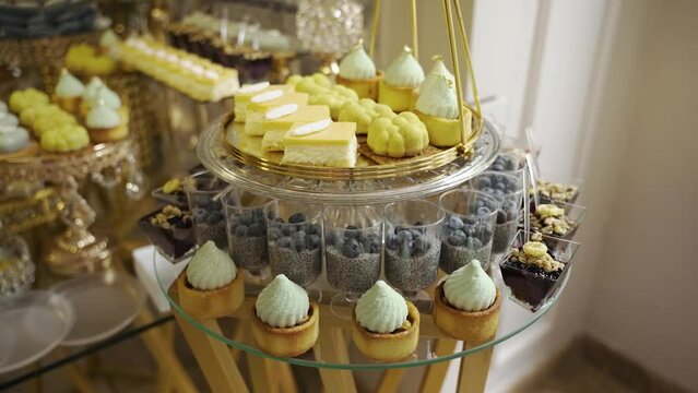 Candy bar.Sweets. Delicious desserts at banquet. Mousse desserts, sponge cakes, shortbread tarts, chocolate desserts, dietary dessert with chia seeds and fresh blueberries. Confectionery in restaurant