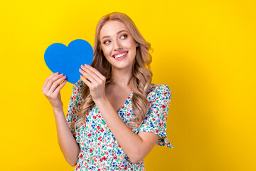 Portrait of gorgeous positive lady wear stylish sarafan hold blue heart love ukraine look empty space isolated on yellow color background