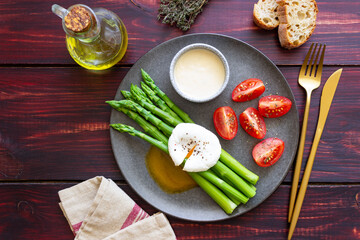 Fototapeta na wymiar Asparagus with poached egg, tomatoes and hollandaise sause . Healthy eating. Vegetarian food.
