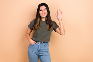 Photo of adorable nice asian lady waving arm meet friends say hey hi hello wear casual clothes isolated beige color background © deagreez