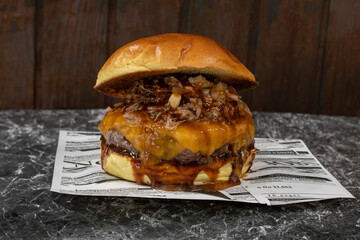 Detalle de una hamburguesa, con queso, salsa barbacoa, y carne triturada