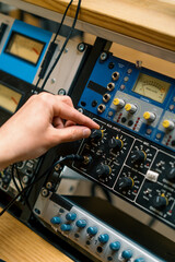 Fototapeta na wymiar Sound engineer using digital audio mixer sliders Engineer pressing keys adds control panel volume Recording studio technician close up