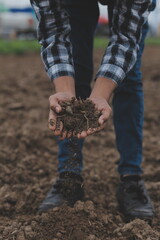 Male hands touching soil on the field. A farmer checks quality of soil before sowing. Agriculture,...