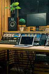 A recording studio control panel mixer with an equalizer faders buttons for broadcasting a recording of song