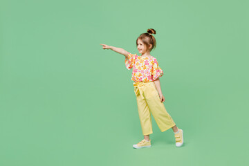 Full body little child kid girl 6-7 years old wear casual clothes point index finger aside on area...