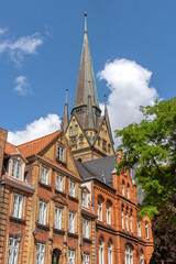 Fototapeta na wymiar Backsteinhäuser am Südermarkt mit Nikolaikirche im Hintergrund in der historischen Altstadt von Flensburg