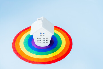 Ceramic house statuette standing on LGBTQ colors aim platform. Friendly home love acceptance family...