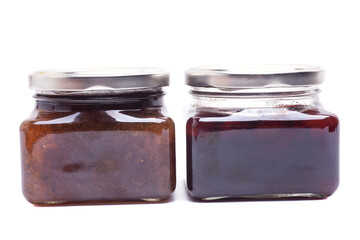 Delicious dogwood and feijoa jam in glass jars isolated on white.