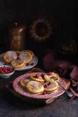 Fresh homemade pancakes with raspberries on vintage plates on a dark background. Close up - 611049508