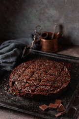 homemade chocolate cake on a vintage baking sheet against a dark background - 611050127