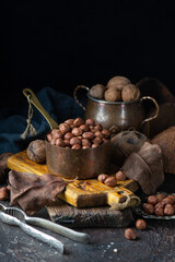 Walnuts, hazelnuts, coconut on grunge table surrounded by vintage utensils. Close up - 611050730