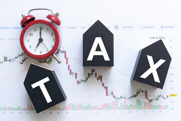 TAX wooden cubes on the chart background , look through a magnifier
