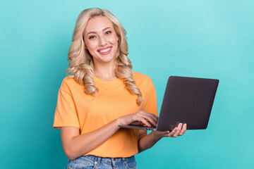 Photo of positive cute lady dressed orange t-shirt chatting instagram twitter telegram facebook isolated teal color background