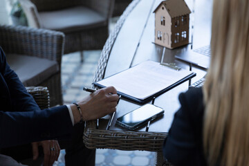Businessman signing contract with estate agent in agency office. Potential client ready for buying...