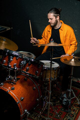 Fototapeta na wymiar a young male drummer plays a drum kit in a recording studio at a professional musician's rehearsal recording a song