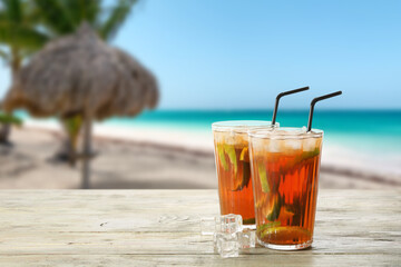 Glasses of tasty cold ice tea on table at sea resort