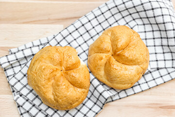 Kaiser rolls with napkin on table, closeup