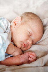 Little newborn baby boy sleeping in the bed