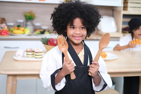 Adorable girls enjoy making baked goods in pastry and bakery class at culinary school..